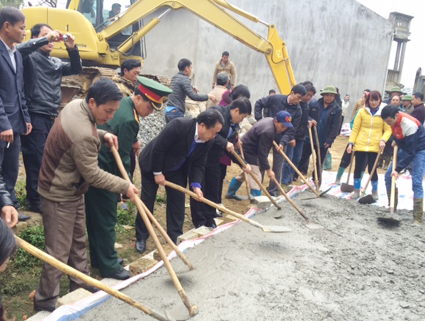 Cán bộ, nhân dân huyện Si Ma Cai tham gia đổ bê tông đường giao thông.